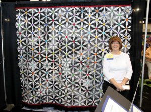 Kay standing with her quilt at Road to California